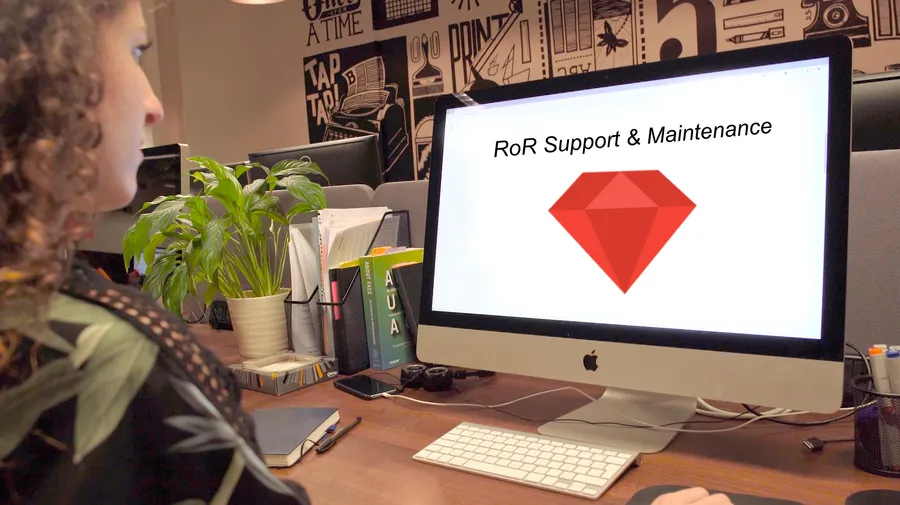Woman at computer conducting support and maintenance of an RoR application