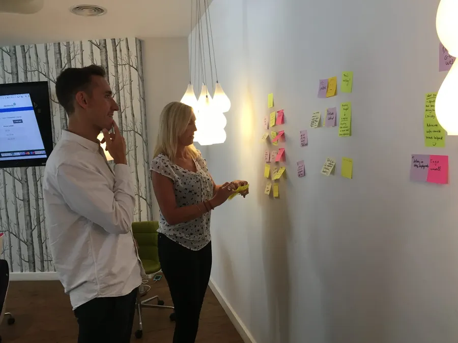 The facilitator of the retrospective guides the team to arrange their comments into groups on the wall.